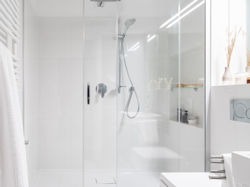 Sliding glass shower enclosure in a white bathroom