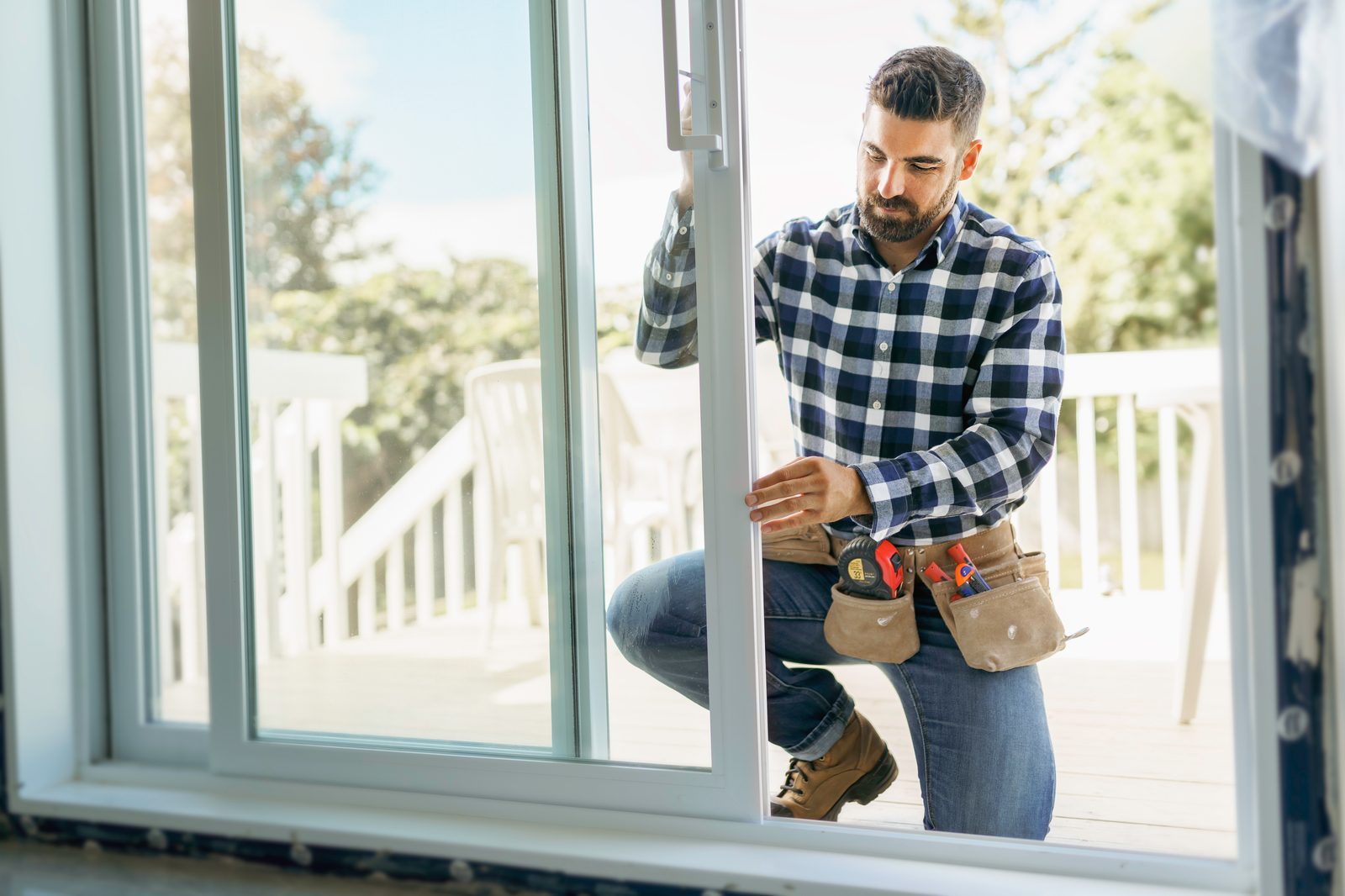 Glass technician fitting a sliding glass door panel at a home