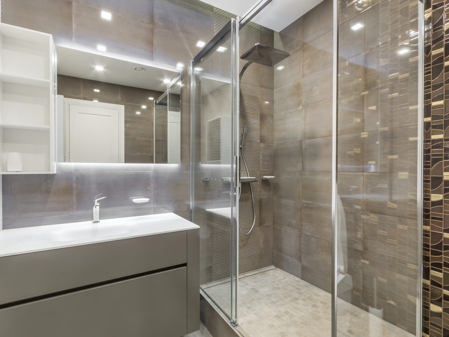 Frameless glass shower enclosure in a tiled bathroom
